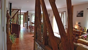 A spacious living area with a high ceiling and exposed wooden beams, a dining area with a table and chairs, and a cozy seating area with a sofa and decorative items. - 3 bedroom awesome home in Lottinghen (Lottinghen)