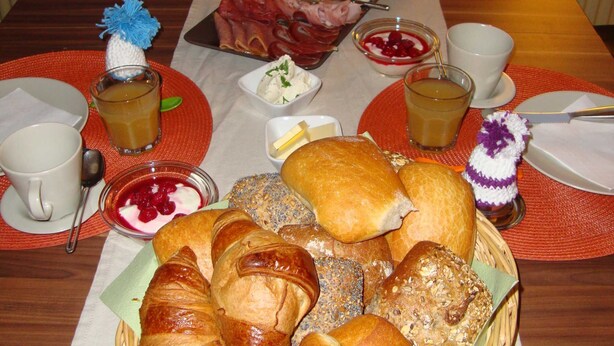Un bufé de desayuno con panes, pasteles y diferentes opciones para untar.
