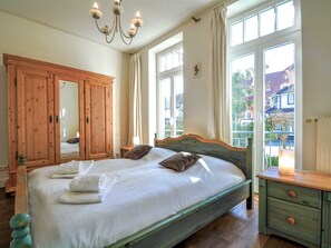 Una camera da letto con un letto grande, un'armadio in legno e vista all'esterno.