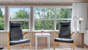 A room with two black leather chairs, a small white table, and a floor lamp. - Cozy home in Nexø with WiFi (Nexø)
