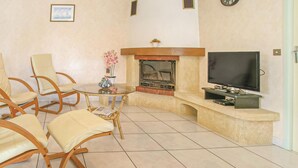A living room with a fireplace, a television, and comfortable seating. - 3 bedroom lovely home in La Tranche sur Mer (La Tranche sur Mer)