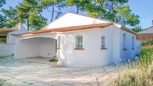 A white house with a tiled roof, a covered porch, and a small garden area. - 3 bedroom lovely home in La Tranche sur Mer (La Tranche sur Mer)