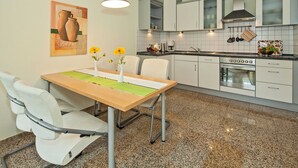 A modern kitchen with white cabinets, a granite countertop, and a stainless steel oven. - Dune Residence C 13 - DR C 13 (Heringsdorf)