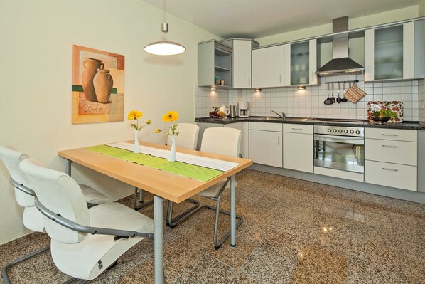A modern kitchen with white cabinets, a granite countertop, and a stainless steel oven.