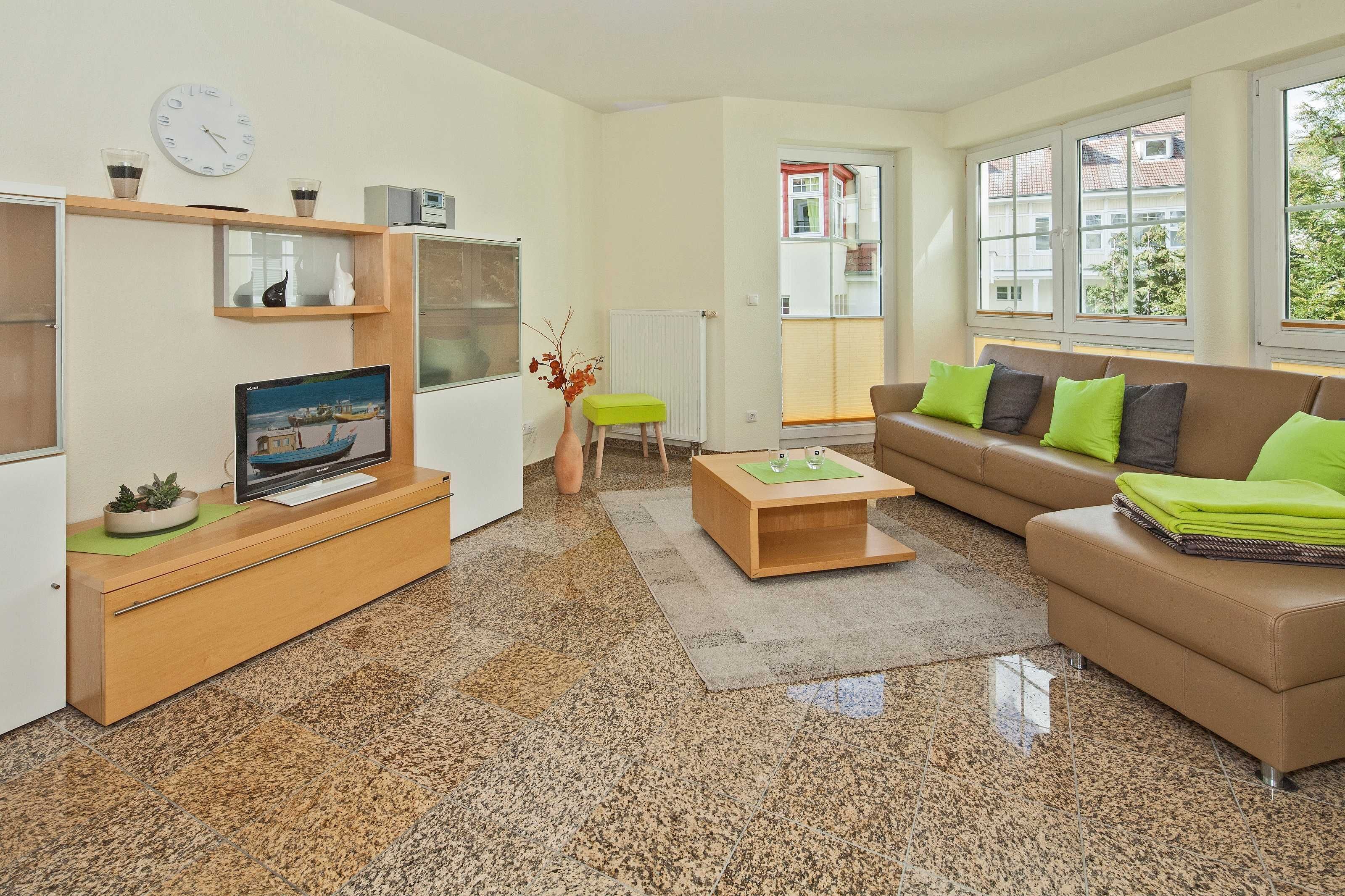 Un salon moderne comprenant un téléviseur, un canapé, une table basse et une petite table d’appoint.