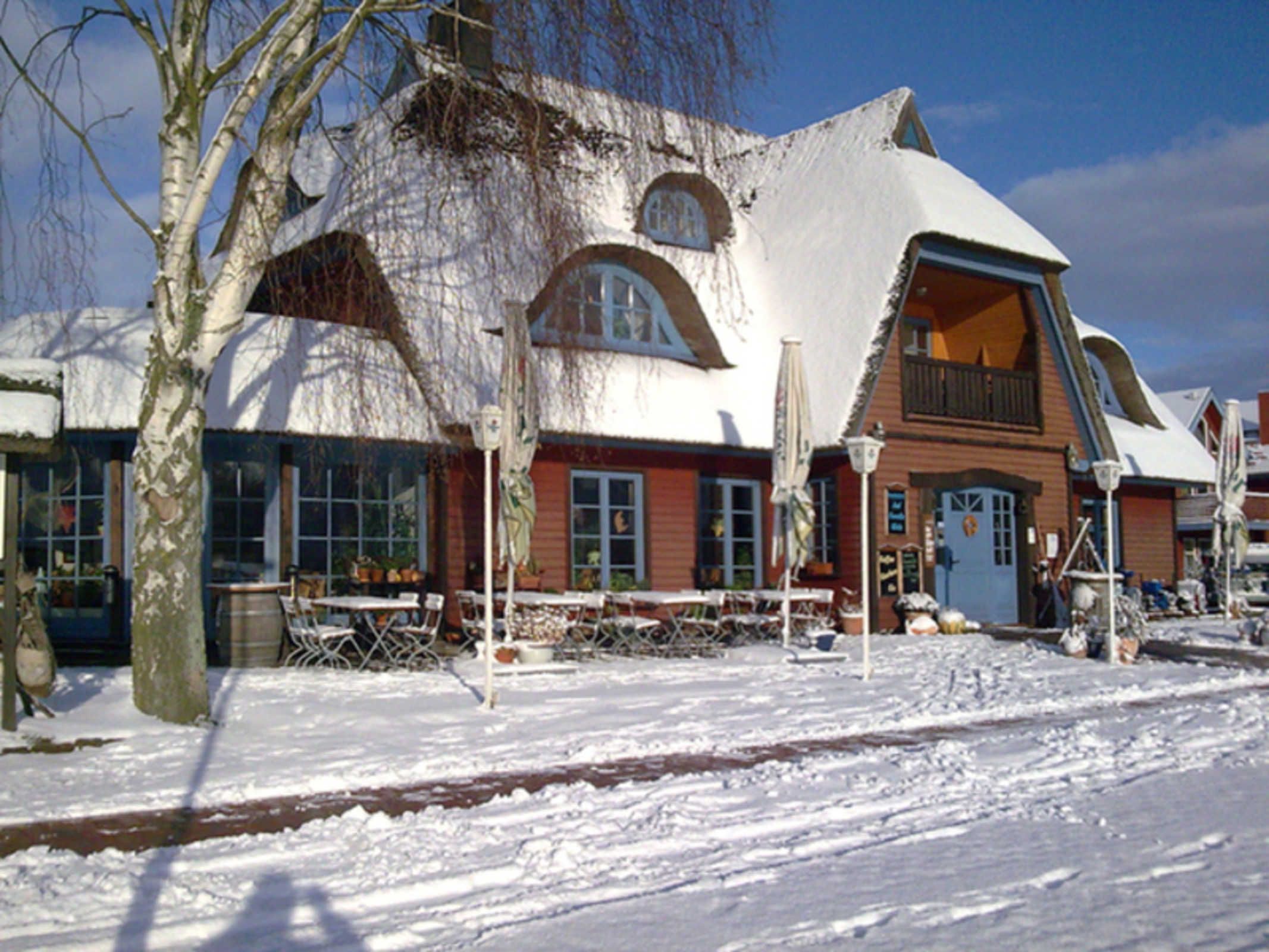 Un bâtiment recouvert de neige, doté d’une architecture originale, avec de grandes fenêtres et un balcon.