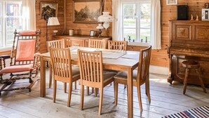 Un comedor de madera con una mesa y sillas, una lámpara y un cuadro en la pared.