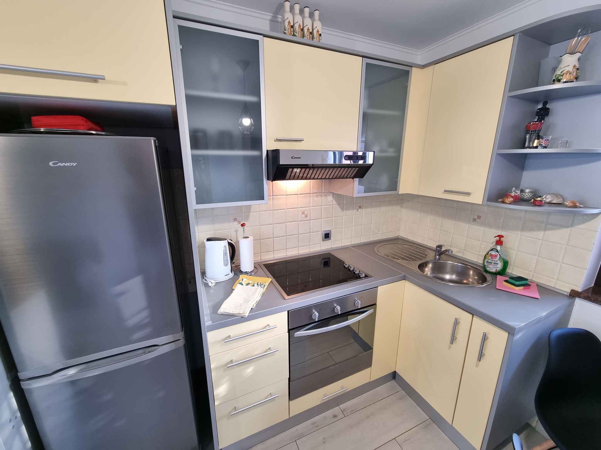 Een moderne keuken met een ingebouwde oven, een koelkast en een spoelbak.