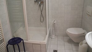 A bathroom with a shower, toilet, and a small stool. - Holiday 2 - Holidays from the I Fam. Roman Kurth / TZR (Putbus)