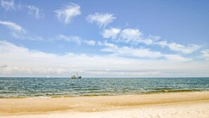 Ein Strand mit sandigem Ufer und ruhiger See.