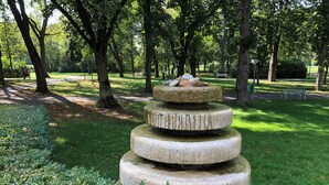 A stone water feature with a tiered design in a park.