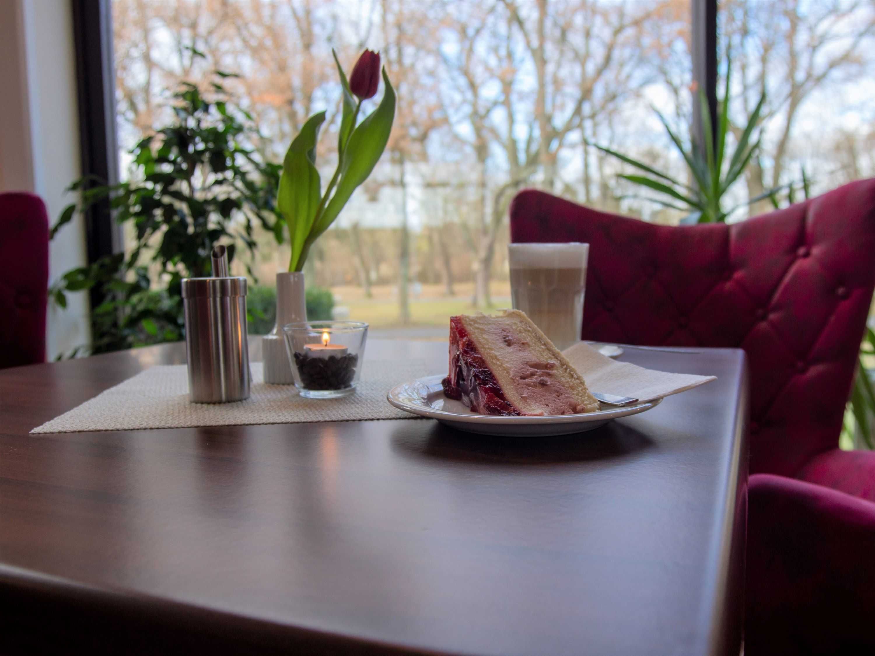 Une table avec une part de gâteau, une bougie et un verre de bière.