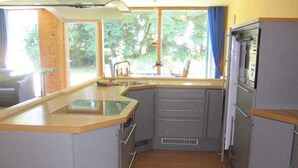 A compact kitchen with a sink, cabinets, and a stove. - Windland Ranch - Riding stables with vacation apartments (House 2) - Apartment Seeadler (Altenkirchen)
