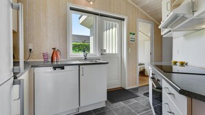 Een moderne keuken met witte kasten, een zwart aanrecht en een raam dat voor natuurlijk licht zorgt.