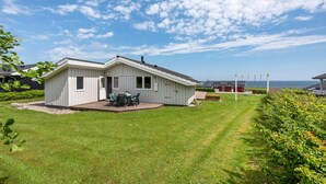 Een gelijkvloers huis met terras en uitzicht op zee.