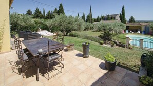 A patio with a table and chairs, a hammock, and a swimming pool in the background. - Cozy home in Caumont sur Durance (Caumont sur Durance)