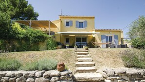 A two-story house with a stone staircase leading to the entrance, surrounded by greenery and a stone wall. - Cozy home in Caumont sur Durance (Caumont sur Durance)