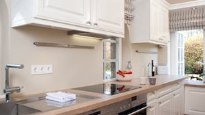 A modern kitchen with white cabinets, a stainless steel sink, and a Siemens oven. - Vis à Vis from A&M - Vis à Vis (Kampen (Sylt))