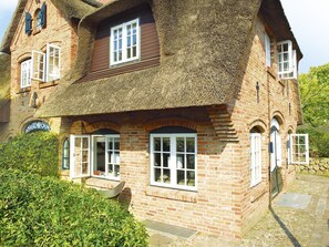 A traditional brick house with a thatched roof, multiple windows, and a small porch area. - Vis à Vis from A&M - Vis à Vis (Kampen (Sylt))