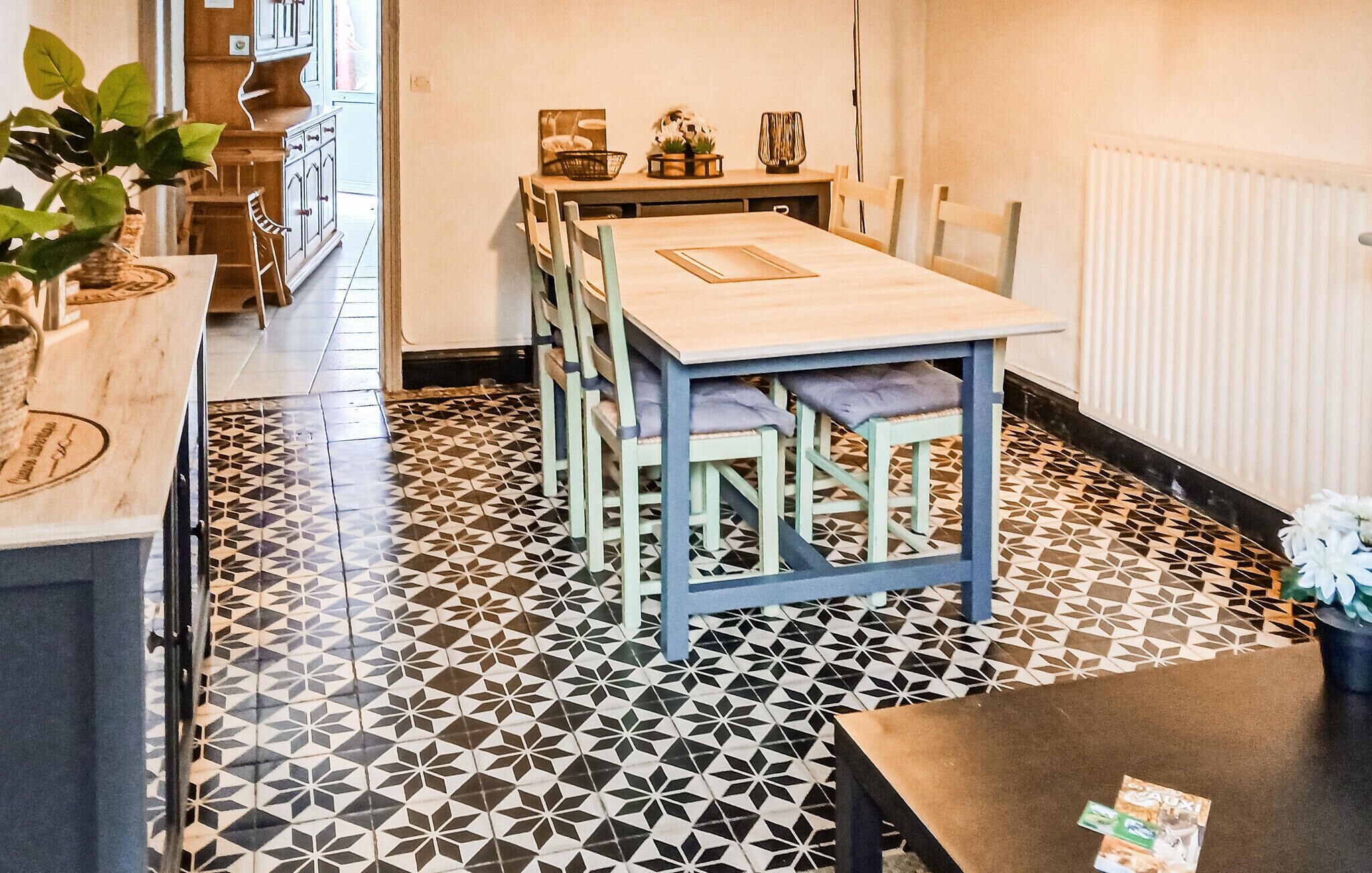 Un espace repas comprenant une table, des chaises et un sol à motifs.
