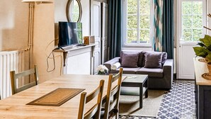 Una sala de estar acogedora con sofá, mesa de centro, televisor y un comedor con sillas y mesa.