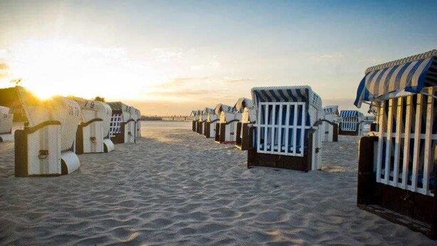 A beach with rows of beach huts and a clear sky. - (166) 2-room apartment - apartment complex Yachthafenresidenz (Kühlungsborn)