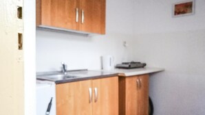 Una cucina con mobili in legno, un piano di lavoro bianco e una macchina da caffè.
