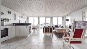A modern kitchen with a built-in oven and a dining area with a view of the outside.