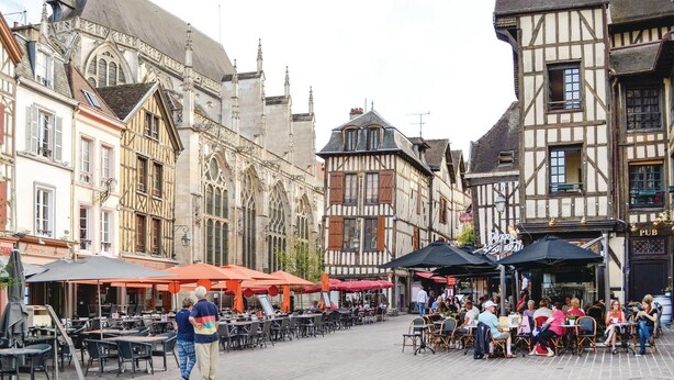 A historic European street with traditional half-timbered buildings, outdoor cafes, and a cobblestone pavement. - Nice home in Landreville with kitchen (Landreville)