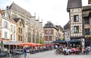 A historic European street with traditional half-timbered buildings, outdoor cafes, and a cobblestone pavement. - Nice home in Landreville with kitchen (Landreville)