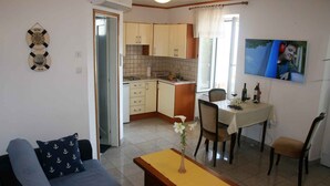 Ein gemütlicher Wohnbereich mit Küchenzeile, Essplatz und Sofa.