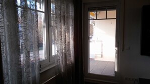 Ein Zimmer mit einem großen Fenster, einer Tür und einem an der Wand befestigten Lichtschalter.