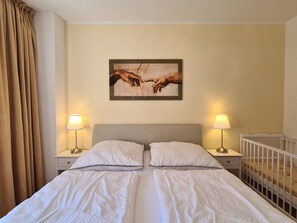 Una cama doble con dos almohadas, cabecera y dos mesitas de noche con lámparas.