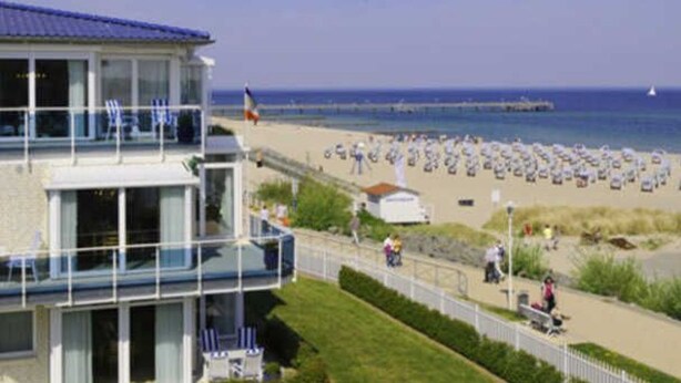Un edificio sul lungomare con un balcone che si affaccia su una spiaggia.