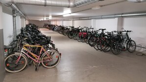 A long, empty indoor parking area with rows of bicycles and scooters. - MB-2. 28 - Ocean View Apt. MB-228th (Kühlungsborn)