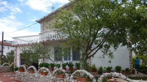 A traditional building with a stone wall and potted plants. - Studio mit Klimaanlage und Balkon (Seline)
