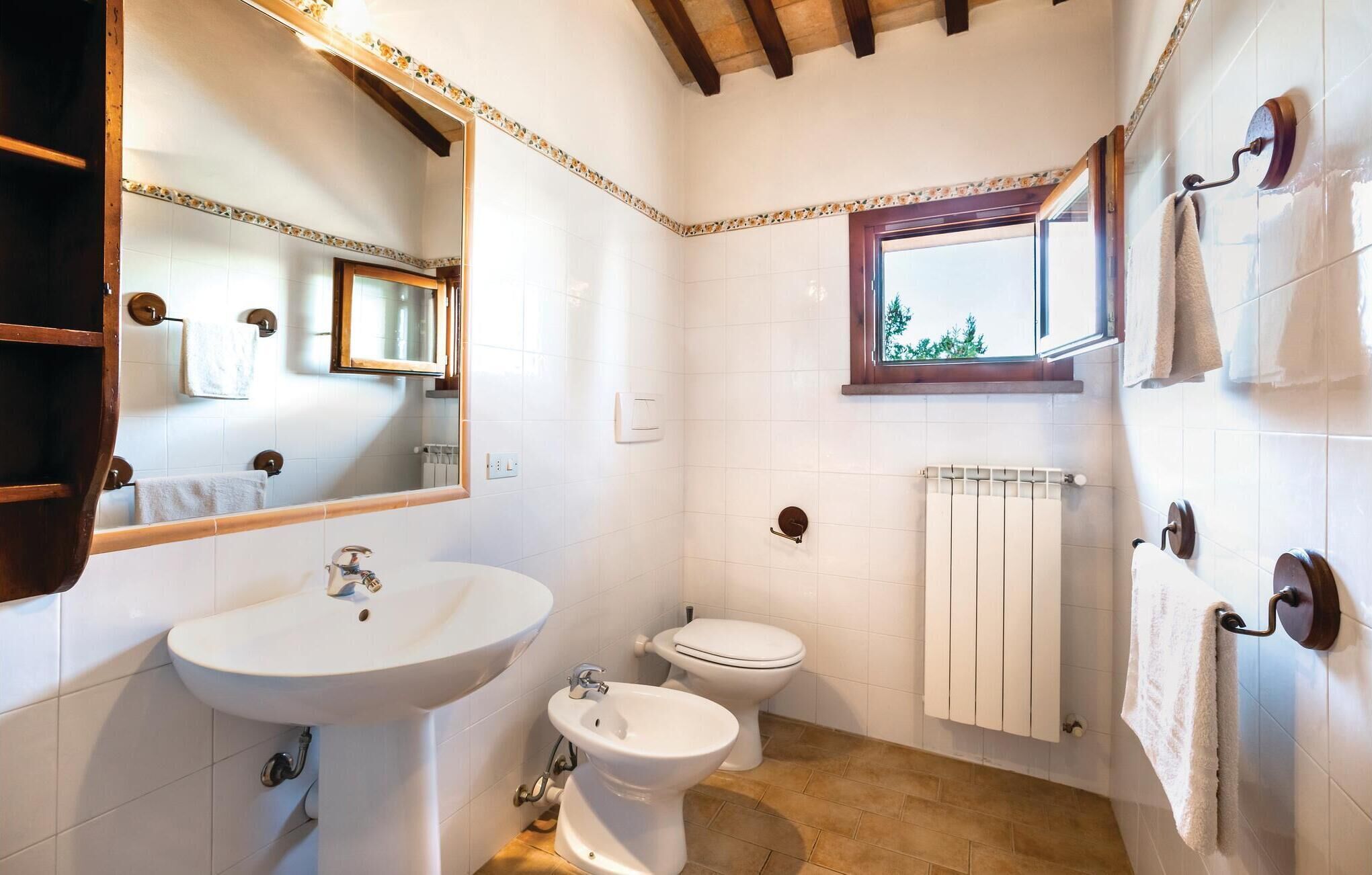 Ein Badezimmer mit Waschbecken, Toilette, Bidet und einem Fenster.