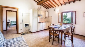A cozy kitchen with a dining table, wooden chairs, and a view through a window. - Cozy apartment in Castelfiorentino FI (Castelfiorentino FI)