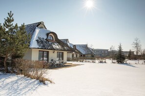 Een gebouw bedekt met sneeuw, met een terras en een heldere lucht.