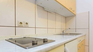 Een moderne keuken met een ingebouwde kookplaat, een spoelbak en een magnetron.