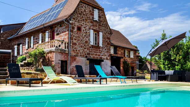 A stone building with a swimming pool, solar panels, and outdoor seating. - Gorgeous home in Badefols D'Ans (Badefols D'Ans)