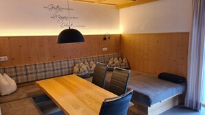 Una habitación acogedora con un banco de madera, una mesa y un sofá.