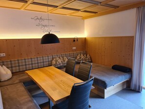 Una habitación acogedora con un banco de madera, una mesa y un sofá.