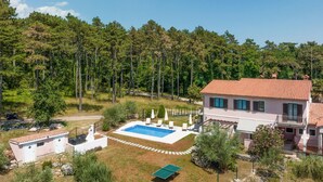 A two-story house with a swimming pool, tennis court, and a forested area in the background. - Awesome apartment in Labin (Labin)