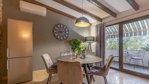 A dining area with a round table, chairs, a clock, and a view of the outdoors. - Awesome apartment in Labin (Labin)