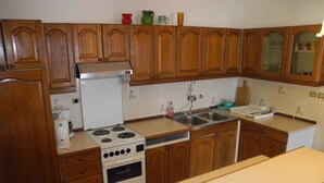 Eine Küche mit Holzausstattung, einem Herd, einem Kühlschrank und einem Spülbecken.