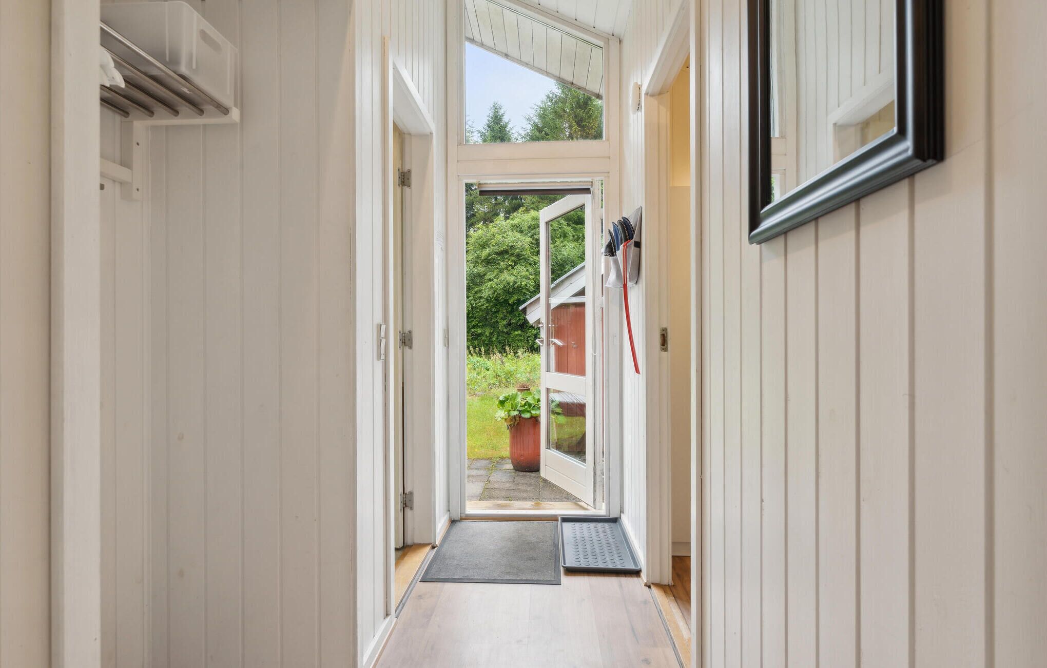Un couloir étroit avec une porte donnant sur un espace extérieur.