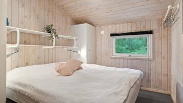 Une chambre à coucher avec un lit, une fenêtre et des murs en bois.