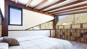 A bedroom with a bed, a window, and a view of a forest. - Casa Rural Altos Cruz de Tea (Granadilla de Abona)