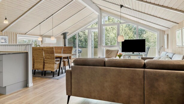A spacious living area with a high ceiling, a large window, a flat-screen TV, and a comfortable sofa. - Beautiful home in Rømø with kitchen (Rømø)